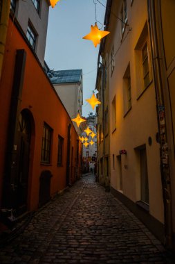 Yıldız çelenk ile eski şehir Riga, Letonya Rozena sokakta dar. Noel dekorasyon Avrupa sokakta. Rozena iela