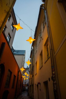 Yıldız çelenk ile eski şehir Riga, Letonya Rozena sokakta dar. Noel dekorasyon Avrupa sokakta. Rozena iela