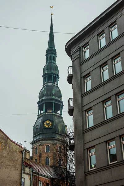 Riga, Latvia: Spire Church of St. Peter is one of the symbols and one of the main sights of the city of Riga. Golden pawn on top — Stock Photo, Image