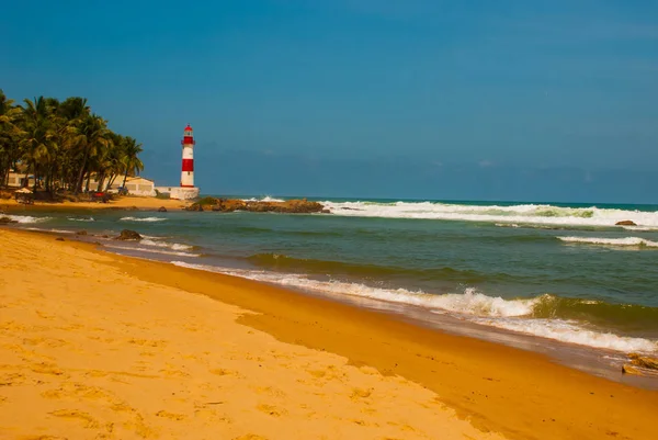 SALVADOR, BAHIA, BRASILE: Farol De Itapua sul mare mosso. Faro sulla spiaggia con tempo soleggiato . — Foto Stock