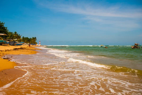 萨尔瓦多，巴伊亚，巴西：法罗尔德伊塔普阿在粗糙的大海。阳光明媚的海滩上的灯塔. — 图库照片