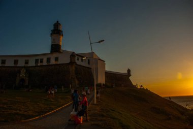 Salvador, Brezilya: Gün batımı. Renkli işareti sömürge Farol da Barra deniz feneri, Güney Amerika'nın en eski önünde duruyor.