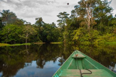 Amazon nehri, Manaus, Amazonas, Brezilya: Amazon ormanının durgun sularında Amazon nehri üzerinde yüzen ahşap tekne.