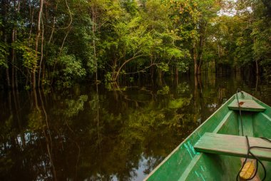 Amazon nehri, Manaus, Amazonas, Brezilya: Amazon ormanının durgun sularında Amazon nehri üzerinde yüzen ahşap tekne.