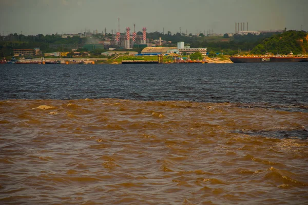 马纳斯，亚马逊，巴西：两个彩色河的合并，里奥内格罗，索利莫斯。会议，多彩的水域不混合，并继续并排的方式，因此每条河流保持与自己的共同 — 图库照片