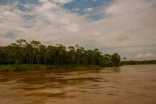Wooden house on the river bank, Amazon River, rainy season. Amazon river, Amazonas, Brazil