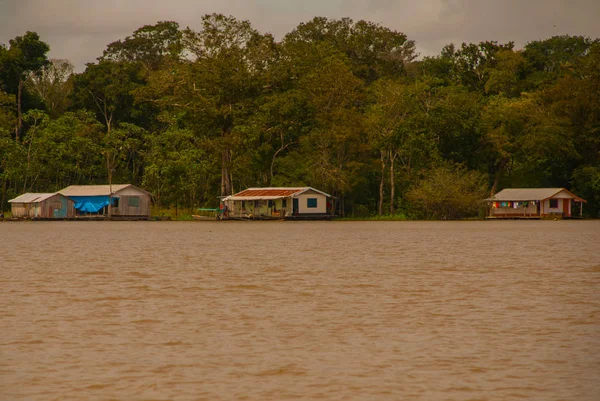 Dřevěný dům na břehu řeky Amazonky, období dešťů. Amazon River, Amazonas, Brazil — Stock fotografie