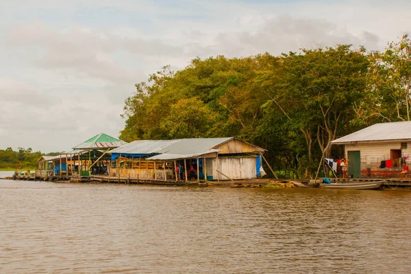 Река Амазонка, Амазонас, Бразилия: Деревянные местные хижины, дома на реке Амазонка в Бразилии . — стоковое фото