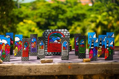 OLINDA, PERNAMBUCO, BRAZIL: Brazilian art and craft carved on a tree bark and painted with vibrant colors representing the colorful building of Olinda in Pernambuco, Brazil. Market clipart