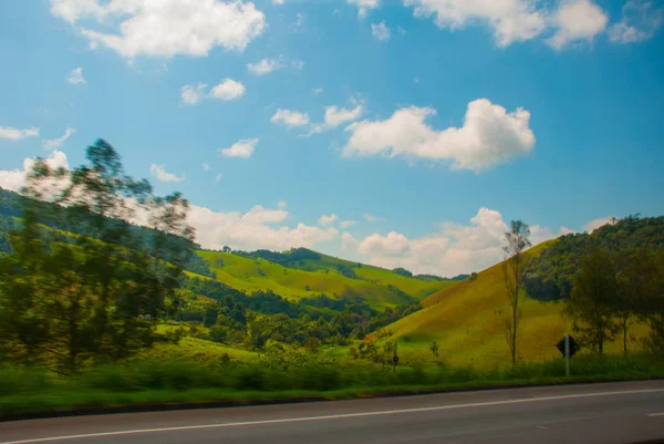 Bela paisagem com vista para campos e colinas com nuvens brancas e céu azul. Brasil — Fotografia de Stock