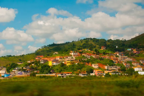 Pequeños pueblos en el camino a Río de Janeiro. Hermoso paisaje con vistas a campos y colinas con nubes blancas y cielo azul. Brasil — Foto de Stock
