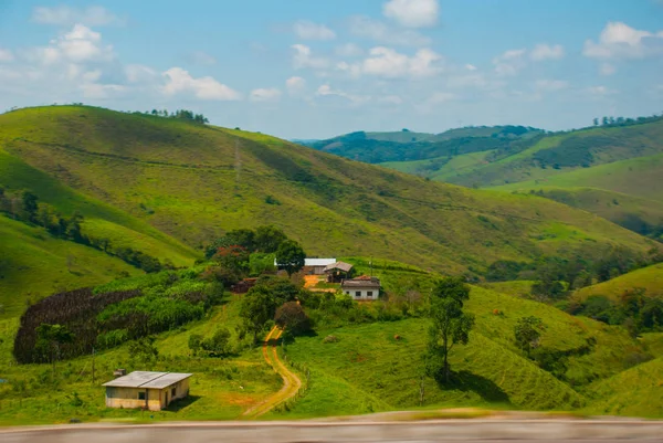 Beautiful landscape overlooking fields and hills with white clouds and blue sky. Brazil