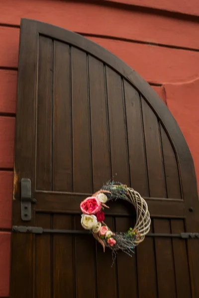 Prag, Tschechische Republik: schöne alte Holztür. Toreingang mit einem Kranz aus Blumen. — Stockfoto