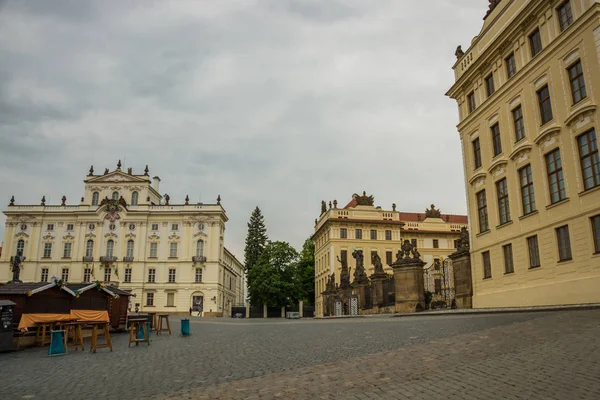 Praga, República Checa: Guardias en la Batalla de Titanes estatuas en la puerta del Primer Patio en el Castillo de Hrad con el Palacio de los Arzobispos detrás en Praga — Foto de Stock