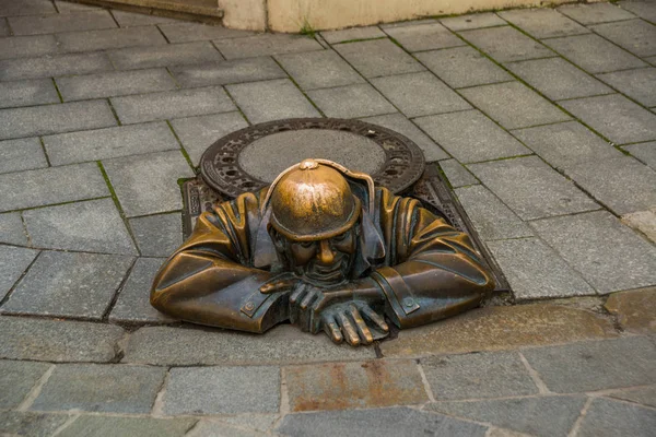 BRATISLAVA, ESLOVÁQUIA: Escultura em bronze de encanador em Bratislava. Estátua Sr. Cumil. O Observador ou Homem a trabalhar . — Fotografia de Stock