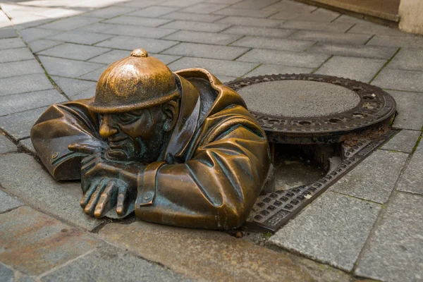 BRATISLAVA, ESLOVÁQUIA: Escultura em bronze de encanador em Bratislava. Estátua Sr. Cumil. O Observador ou Homem a trabalhar . — Fotografia de Stock