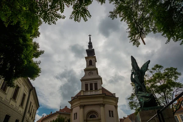 Budapešť, Maďarsko: krásná katolická církev a památník s křížkem a křídly, před rybářskou baštou v srdci Budínského hradu — Stock fotografie