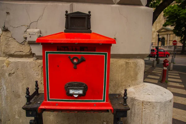 Budapeszt, Węgry. Jasnoczerwona Skrzynka pocztowa z gniazdem dla liter, z płaskorzeźby z rogu poczty, z podporami nóg — Zdjęcie stockowe