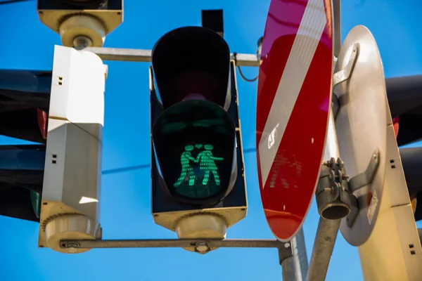 Viena, Áustria: semáforo com cor verde no fundo azul do céu. Luzes de trânsito com homens de mãos dadas e um coração entre as cabeças — Fotografia de Stock