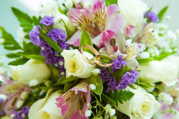 Hermoso ramo de boda delicado de rosas blancas y anillos de boda de la novia y el novio . — Foto de Stock