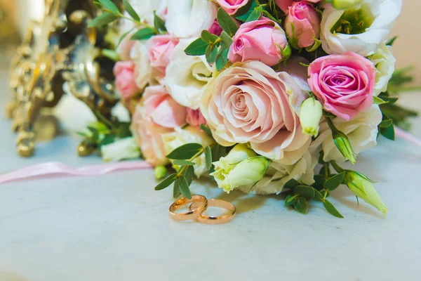 Hermoso ramo de boda delicado de rosas blancas y rosadas y anillos de boda de la novia y el novio . — Foto de Stock