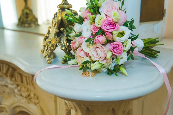 Mooie delicate bruiloft boeket van witte en roze rozen en trouwringen van de bruid en bruidegom. — Stockfoto