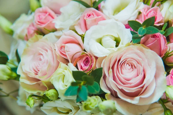 Hermoso ramo de boda delicado de rosas blancas y rosadas y anillos de boda de la novia y el novio . —  Fotos de Stock