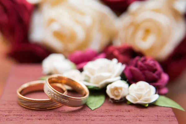 Anéis de casamento da noiva e do noivo em um lindo buquê de casamento de rosas vermelhas e brancas — Fotografia de Stock