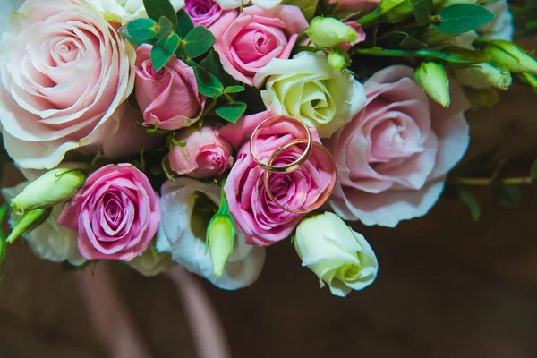 Hermoso ramo de boda delicado de rosas blancas y rosadas y anillos de boda de la novia y el novio . — Foto de Stock