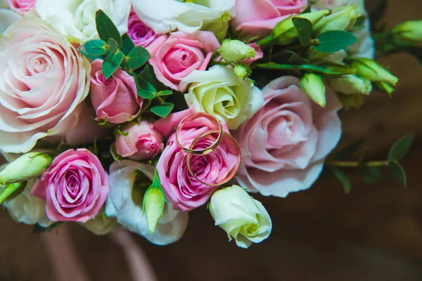Hermoso ramo de boda delicado de rosas blancas y rosadas y anillos de boda de la novia y el novio . — Foto de Stock