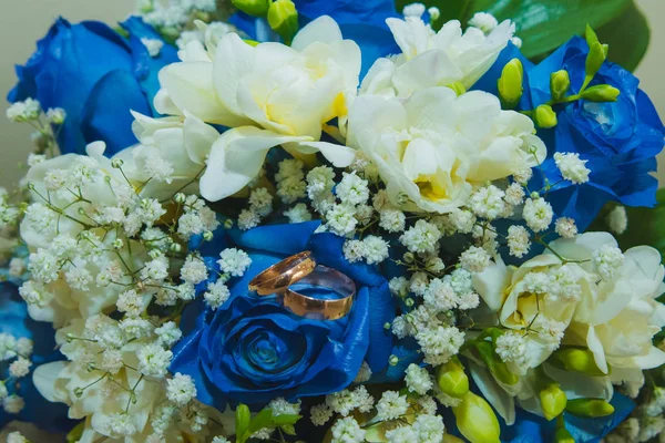 Hermoso ramo de boda delicado de rosas azules y anillos de boda de la novia y el novio . — Foto de Stock