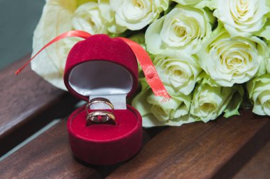 Kırmızı bir kutu içinde gelin ve damat beyaz gül ve alyans güzel hassas düğün buketi