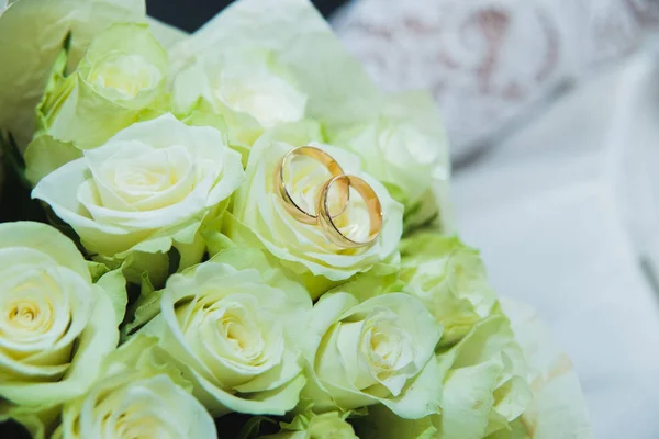 Hermoso ramo de boda delicado de rosas blancas y anillos de boda de la novia y el novio . — Foto de Stock