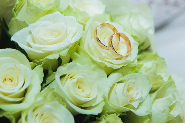 Belo buquê de casamento delicado de rosas brancas e anéis de casamento da noiva e do noivo . — Fotografia de Stock
