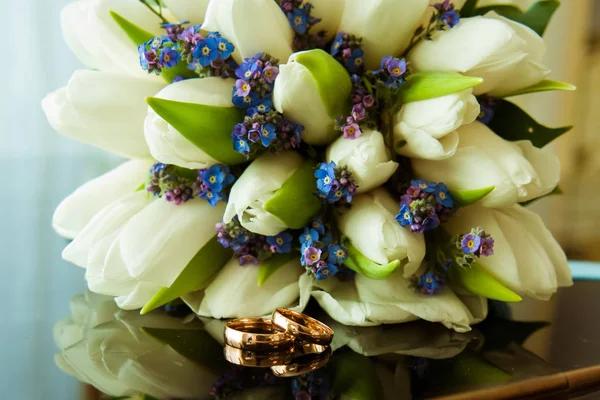 Anillos de boda de la novia y el novio en un hermoso ramo de boda de tulipanes blancos — Foto de Stock
