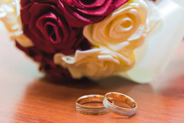 Γαμήλιες βέρες της νύφης και του γαμπρού σε μια όμορφη γαμήλια ανθοδέσμη από κόκκινα και άσπρα τριαντάφυλλα — Φωτογραφία Αρχείου
