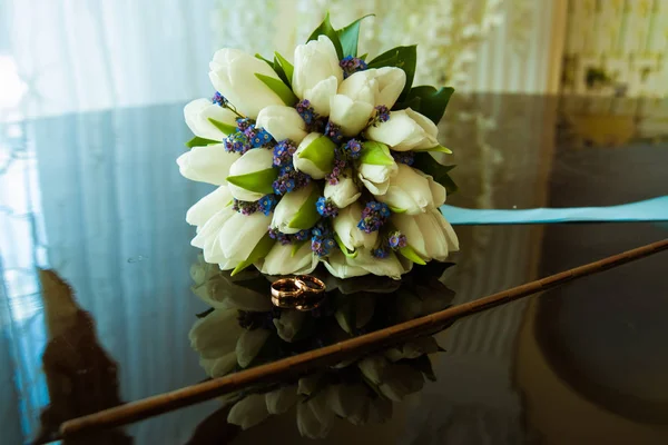 Anillos de boda de la novia y el novio en un hermoso ramo de boda de tulipanes blancos — Foto de Stock