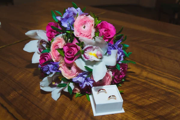 Anelli nuziali degli sposi su un bellissimo bouquet da sposa. Scatola anello bianco — Foto Stock