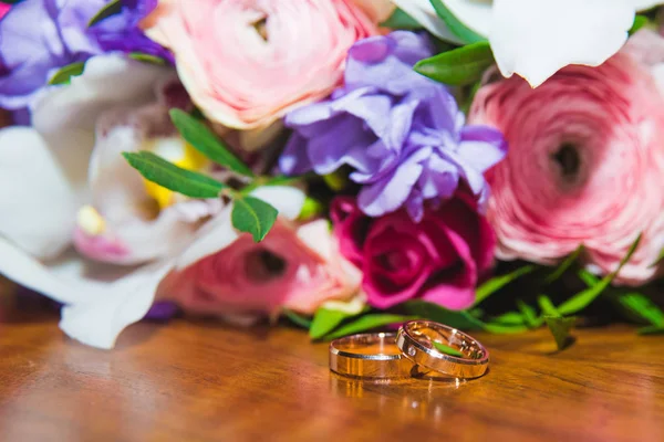 Anelli nuziali degli sposi su un bellissimo bouquet da sposa — Foto Stock