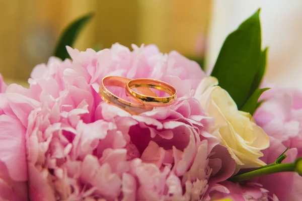 Belo buquê de casamento delicado de peônias rosa e anéis de casamento da noiva e do noivo . — Fotografia de Stock
