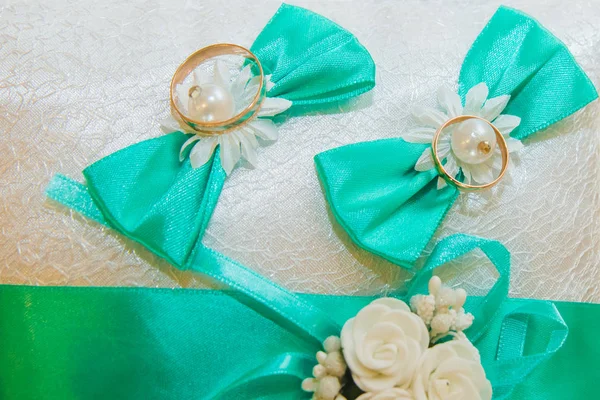 Los anillos de boda están en una almohada blanca y tristemente el ramo de la novia . — Foto de Stock