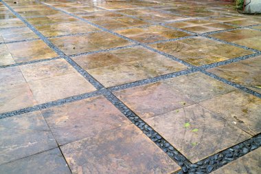 Verandada çakıl taşı kenarlı ıslak taş fayanslar..