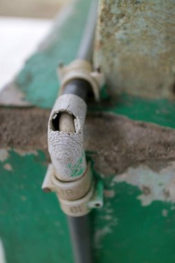 Yeşil boya ve betonla çatlamış bir PVC borusunu kapat..