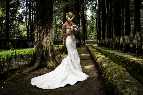 Romantic bride with a wedding dress in the forest