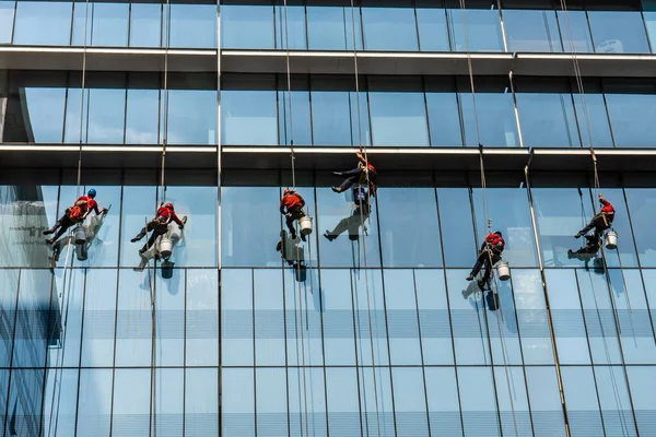 Very high building with men washing the windows