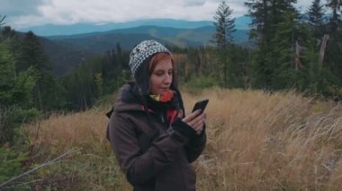 kadın onun smartphone kullanarak dağlarda fotoğraf çekmek