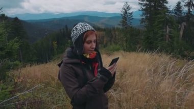 kadın onun smartphone kullanarak dağlarda fotoğraf çekmek