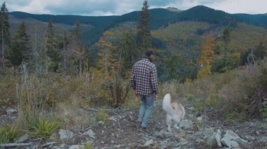 Beyaz erkek Sibirya husky köpek ile dağlarda hiking