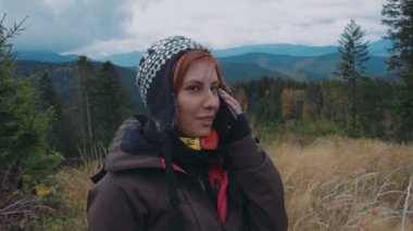 dağlarda telefonda konuşan genç uzun yürüyüşe çıkan kimse kadın