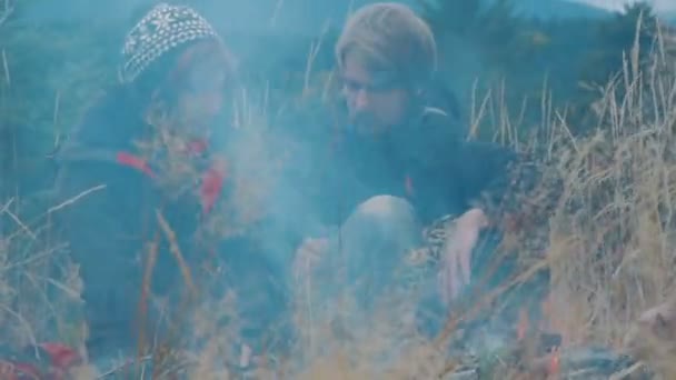 groupe d'amis assis près du feu de camp dans les montagnes 